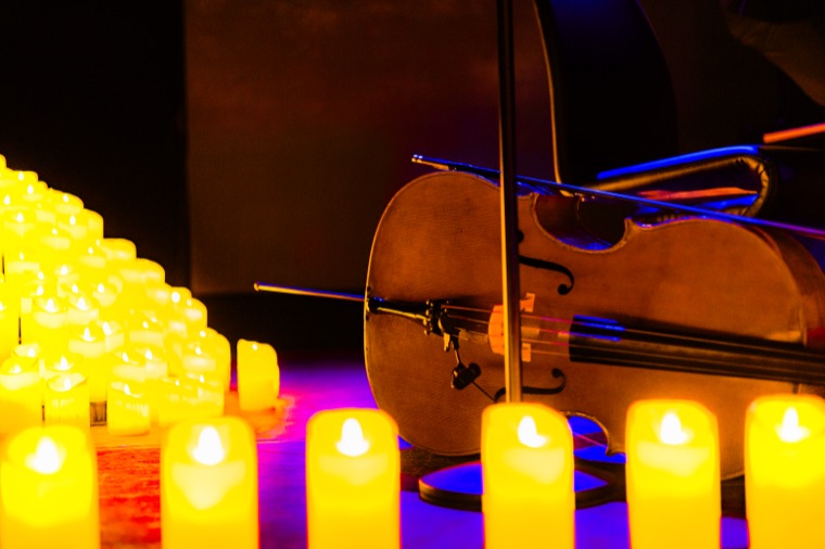 Cello resting among glowing candles