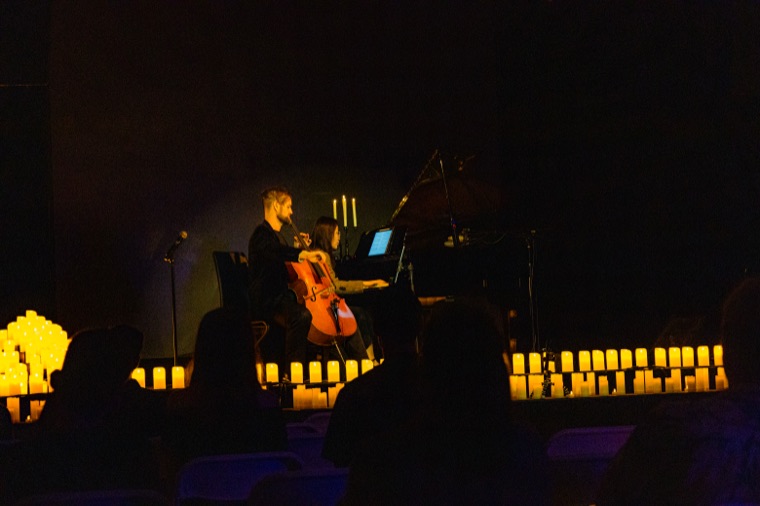 The darkened concert hall with the candlelit stage in the distance