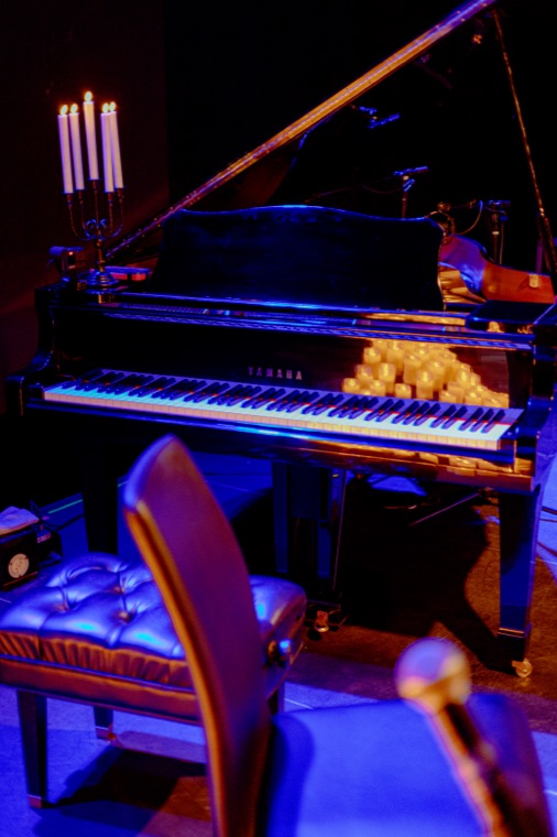 Grand piano lit by rows of candles